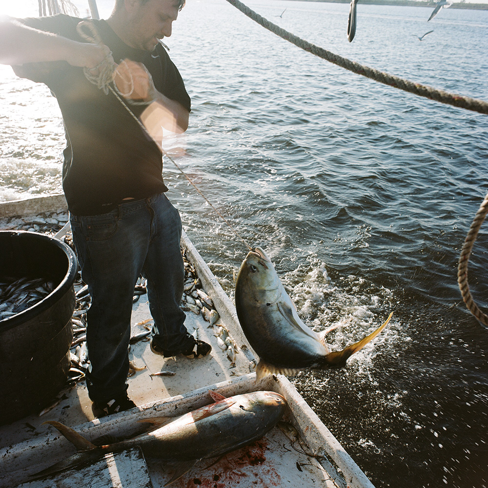 Corey Ruiz catches an amberjack with a hook and string on the shrimp boat, 2012.