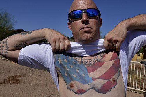 The leader of an anti-Islam rally boasts his patriotic “HARD KNOCK LIFE” tattoo. He later played a significant role in the anti-government armed occupation of Malheur National Wildlife Refuge in Oregon, Phoenix, AZ (2015).