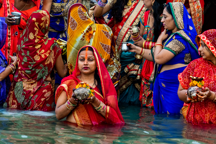 Family offerings and personal devotion stand shoulder to shoulder on the ghats.