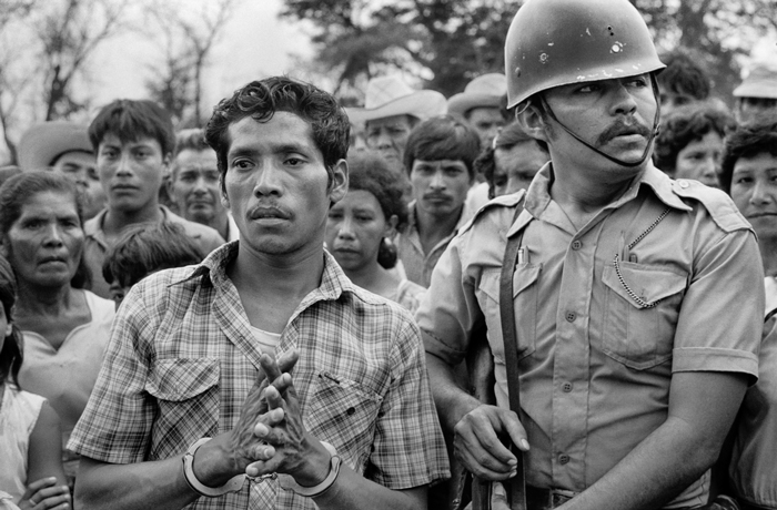 A former member of the government Civil Defense Force, accused of participating in the murder of twelve peasants, is brought to the site of the alleged killings, Los Mangos, Sonsonante Department, El Salvador, April 1984.