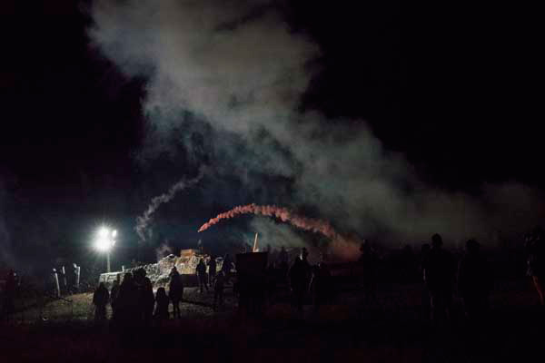 Throwing back tear gas towards the police.